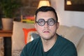 Man with vision difficulties wearing obsolete prescription eyeglasses