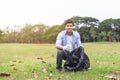 Man volunteer pick garbage bottle plastic clean up environment in green park