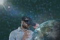 Man in VR headset looking to a 3D planet against green background with flares