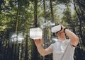Man in VR headset touching interface against woods background Royalty Free Stock Photo