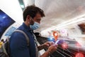 Man wait for the subway and check with smartphone covid-19 contagion