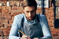 man waiter apron taking order restaurant brick wall