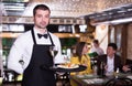 Man waiter is holding tray with wine and salad for clients Royalty Free Stock Photo