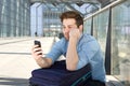 Man waiting at airport with bored expression on face Royalty Free Stock Photo