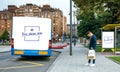 Man waiting bus looking mobile. Customizable bus, bag and canopy Royalty Free Stock Photo