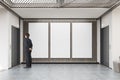 Man waiting for elevator in lobby with three large vertical post Royalty Free Stock Photo