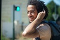 man waiting to cross road wearing headphones