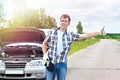 Man waiting to help and showing thumbs up near car