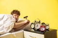 Man wakes up and he& x27;s mad at clock ringing, switches it off with the hammer Royalty Free Stock Photo