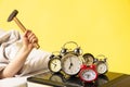 Man wakes up and he& x27;s mad at clock ringing, switches it off with the hammer Royalty Free Stock Photo