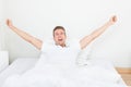 Man waking up in morning and stretching on bed Royalty Free Stock Photo