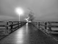 Man walk in autumn mist on wooden pier above sea. Depression, dark atmosphere. Royalty Free Stock Photo