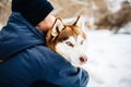 Man walk with his friend red siberian husky dog in snowy park. Toned Royalty Free Stock Photo