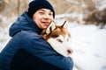 Man walk with his friend red siberian husky dog in snowy park. Toned Royalty Free Stock Photo