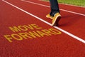 Man walk on the running track with a motivational quote written - MOVE FORWARD