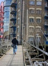 Man walking across bridge toward Concordia Wharf. London. uk