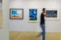 Man Walking and Admiring Paintings in a Modern Art Gallery Royalty Free Stock Photo