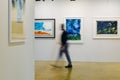 Man Walking and Admiring Paintings in a Modern Art Gallery Royalty Free Stock Photo