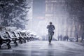 A man walking alone in a cold winter talking on the phone Royalty Free Stock Photo