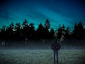 Man walking alone in magical dark foggy wild forest landscape. Royalty Free Stock Photo