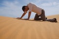 Man walking alone in the sunny desert. He is lost and out of breath. No water and energy. Royalty Free Stock Photo