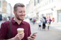 Man Walking Along City Street Reading Text Message On Mobile Phone Royalty Free Stock Photo