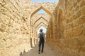 Man Walking Along the Iconic Archways in Bahrain Fort, Manama, Bahrain Royalty Free Stock Photo