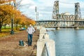 Man walking along the riverwalk in Portland city at autumn