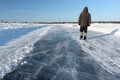 Man walking along a road of ice on the frozen reservoir Royalty Free Stock Photo