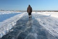 Man walking along a road of ice on the frozen reservoir Royalty Free Stock Photo