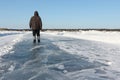 Man walking along a road of ice on the frozen reservoir Royalty Free Stock Photo