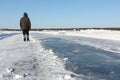 Man walking along a road of ice on the frozen reservoir Royalty Free Stock Photo