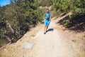 Man walking along a sandy road in a juniper forest