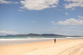 Man walking along a sun-soaked Noosa Beach, Australia Royalty Free Stock Photo