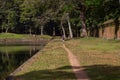 Man Walking by Ancient Wall & Pool in the Cambodian Jungle of Angkor Thom