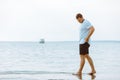 man walking barefoot by sea beach summer time