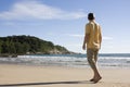 Man walking barefoot on a tropical beach