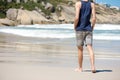 Man walking barefoot on white sand beach Royalty Free Stock Photo