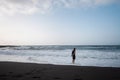 man walking on beach, cloudy weather, beautiful waves of ocean