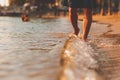 Man walking on the beach and sea water flow in sunset time Royalty Free Stock Photo