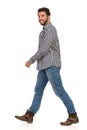 Young Man In Jeans, Boots And Lumberjack Shirt Is Walking Side View Royalty Free Stock Photo