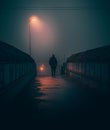 Man walking on a bridge on a foggy night Royalty Free Stock Photo