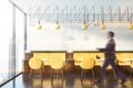 Man walking in cafe with yellow sofas Royalty Free Stock Photo