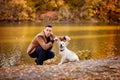 Man walking with dog in autumn Park by river. Royalty Free Stock Photo