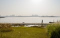 Man walking dog on lakeside planked footbridge in sunny winter a