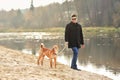 Man walking with dog near the river