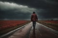 A man is walking down a road in the rain in dramatic weather. A concept of loneliness and depression Royalty Free Stock Photo