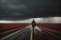 A man is walking down a road in the rain in dramatic weather. A concept of loneliness and depression Royalty Free Stock Photo