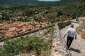 Man walking down stone staircase with roofs of the Moustiers-Sainte-Marie village underneath. Royalty Free Stock Photo