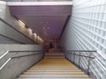 A man walking downstair, stairway to subway, glass block wall,